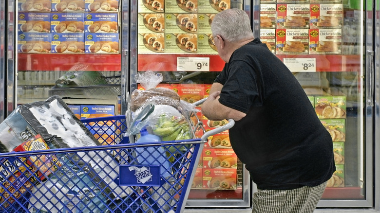 Man looking into a freezer full of food items