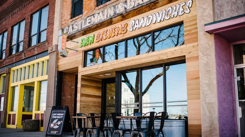 exterior of an Even Stevens Sandwiches shop with a couple of outdoor tables