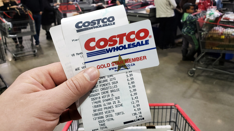 hand holding Costco receipt and membership card