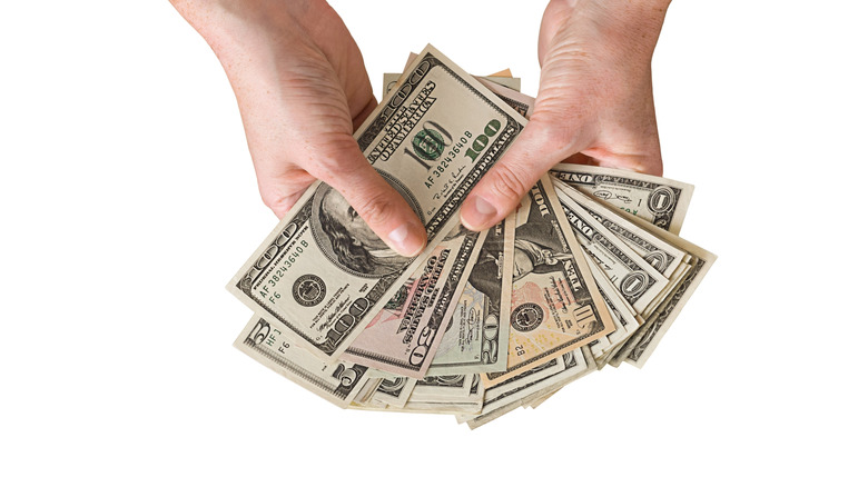 Dollars fanned out in person's hands