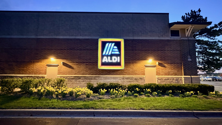 The exterior of an Aldi lit up at night