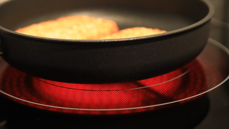A pan on electric stove with glowing element visible