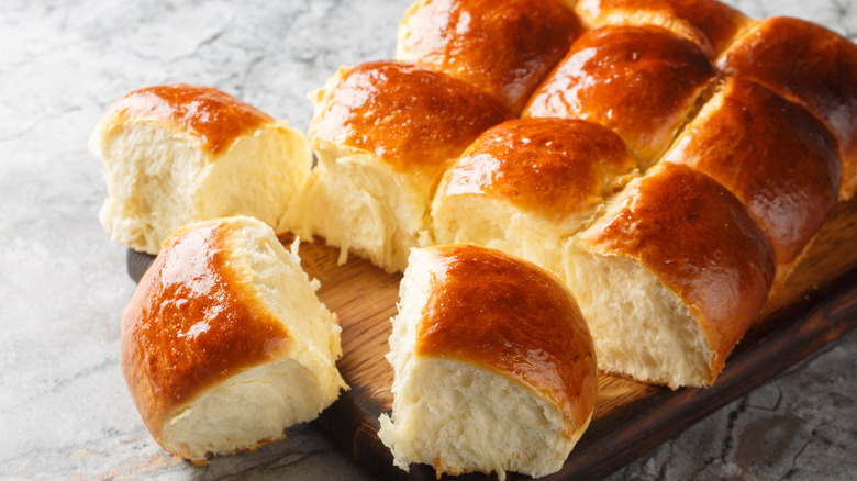 Dinner rolls on a wooden cutting board