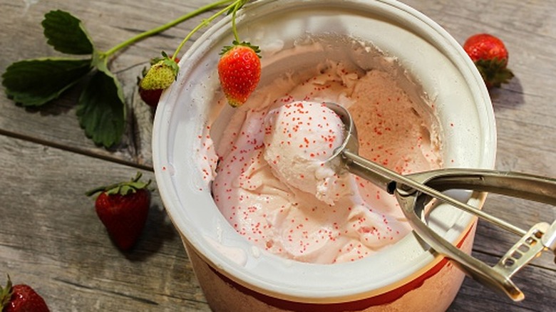 Scooping strawberry ice cream from ice cream maker