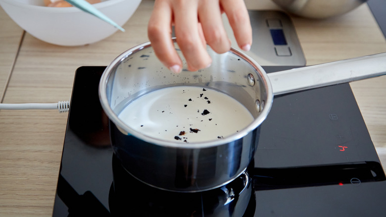 Heating ice cream base on stove, adding fresh vanilla seeds