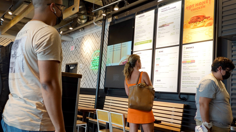 Customers examine the Shake Shack menu.