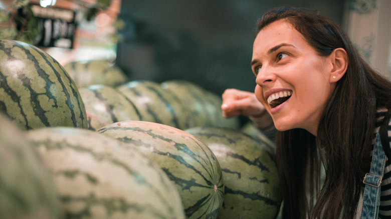 woman knocking on watermelon