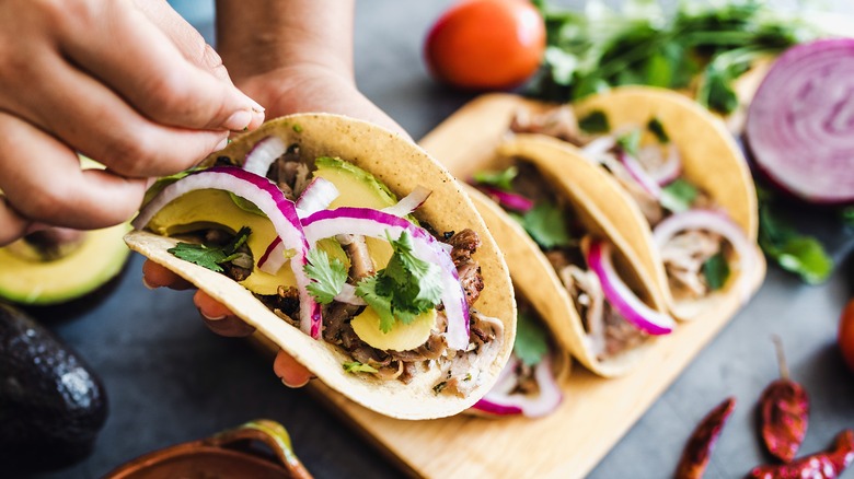 woman garnishing taco