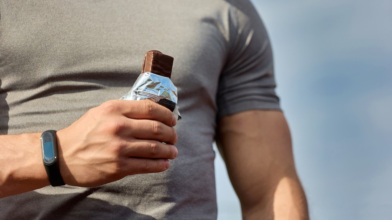 athlete holding protein bar