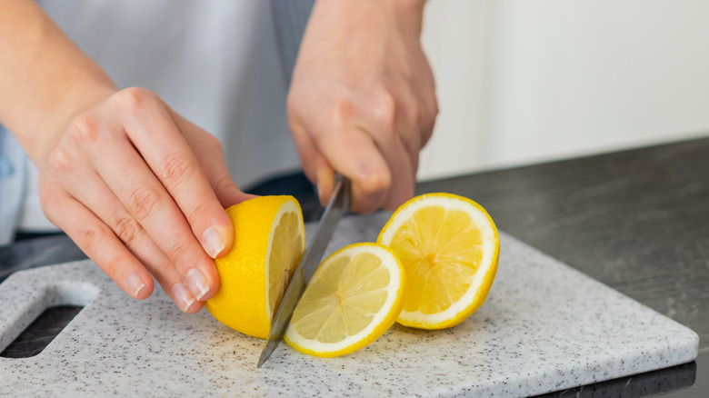 Hands cutting lemons
