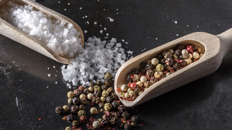 Salt and peppercorns in wooden scoops