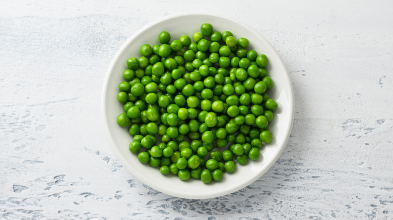 A white bowl of cooked peas