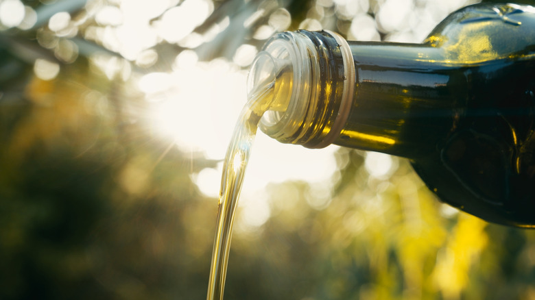 Olive oil pouring from bottle
