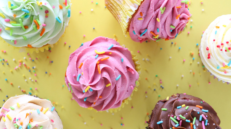 Cupcakes with various colors of frosting and sprinkles on top