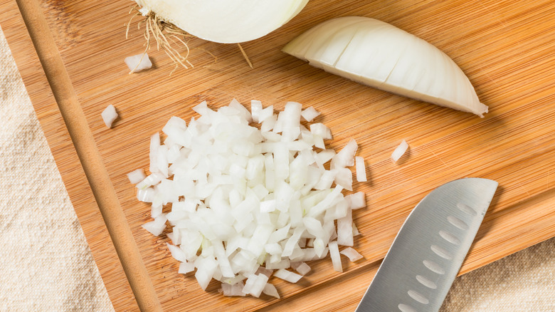 Diced onion on wooden cutting board with knife