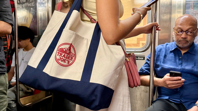 woman carrying Trader Joes shopping tote