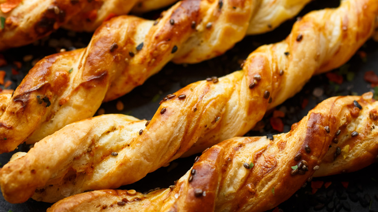 Close-up of cheese straws topped with spices.