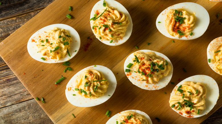 Deviled eggs on a wood cutting board.