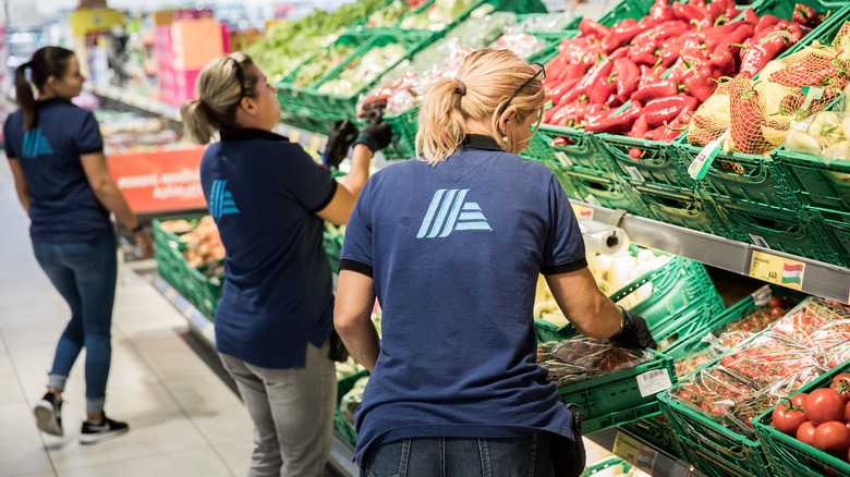 Aldi employees stocking produce