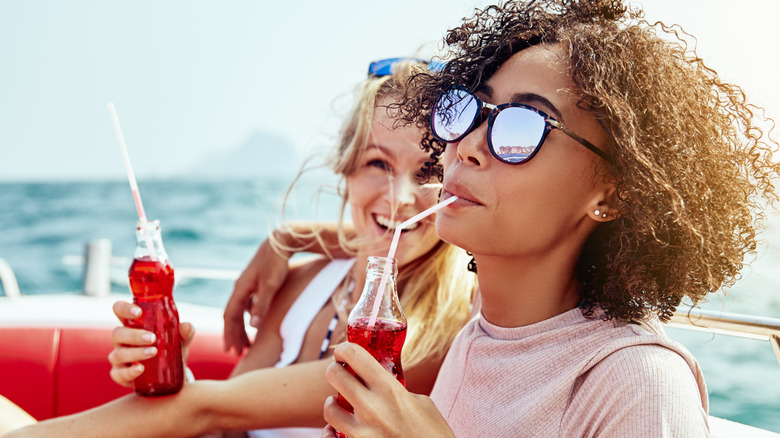 Two women drinking soda on boat