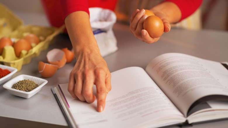 A hand pointing at a cookbook,