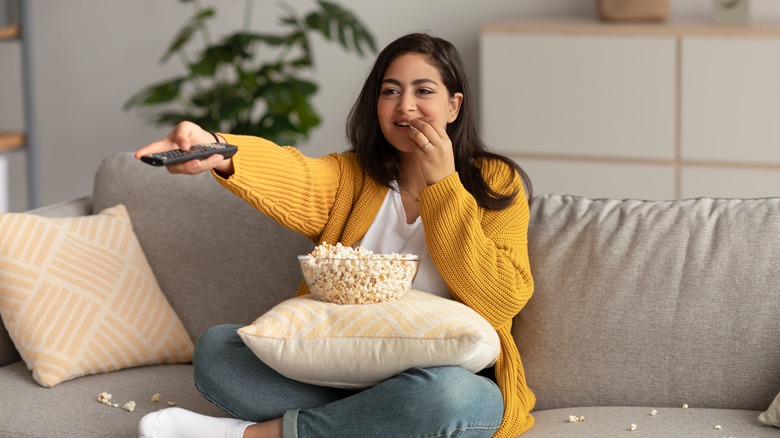 woman watching tv with popcorn