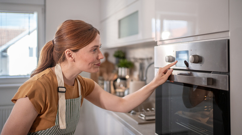 woman setting a timer on the oven