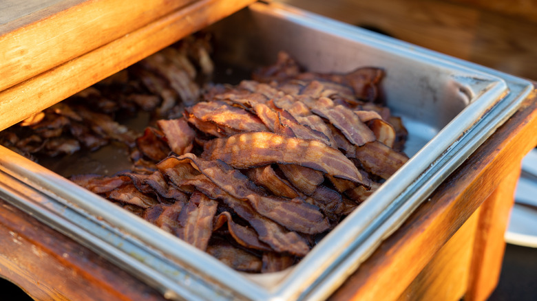 tray of cooked bacon on a buffet