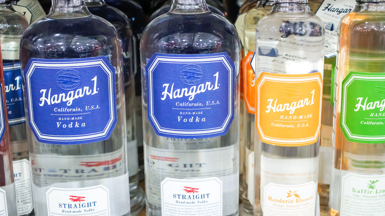 bottle of Hangar 1 vodka on a bar next to a pile of fresh herbs