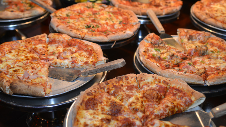 Pizzas on pans at a buffet