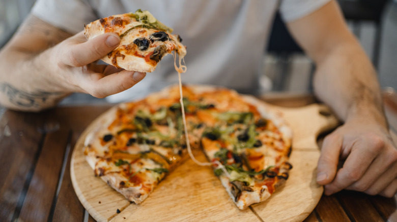 Man with whole pizza pie