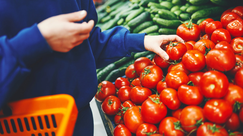 Shopper buying tomatoes