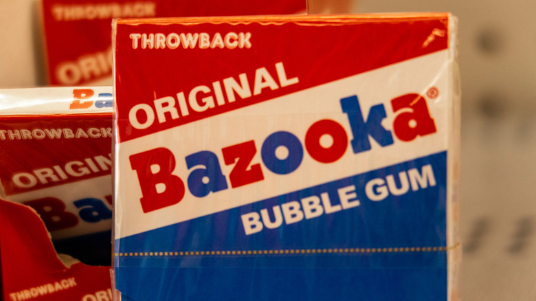 Packs of Bazooka Bubble Gum are stacked in a row.