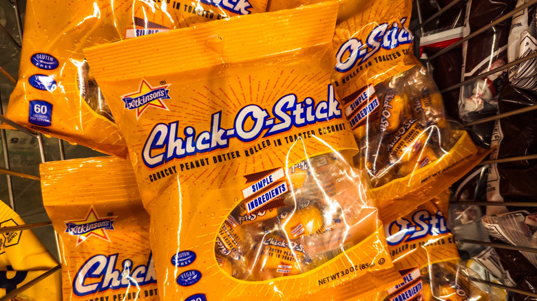 Bags of Chick-O-Sticks candies are piled in a wire basket.