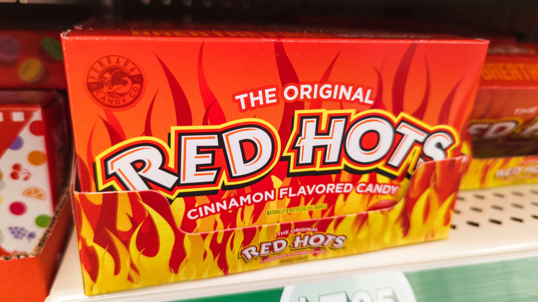A box of Red Hots sit on a store shelf.