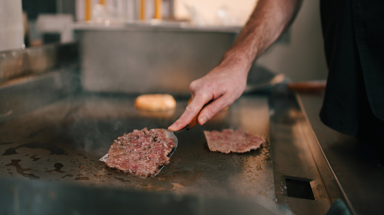 A chef flipping burgers