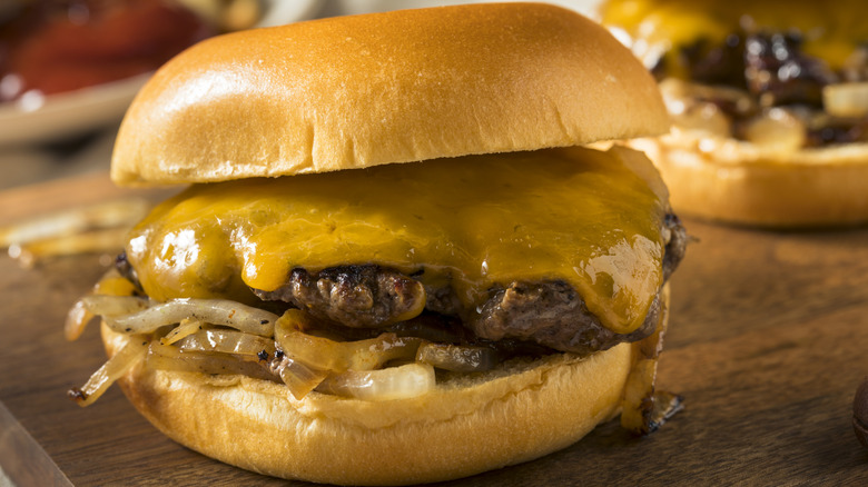 Oklahoma onion burger with cheese on top of a wooden cutting board