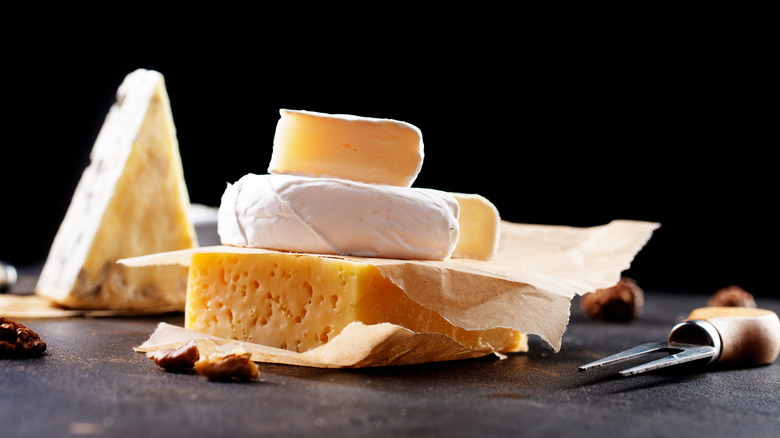 variety of cheeses on a black board