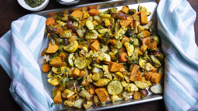 Tray of roasted vegetables with blue and white striped towels