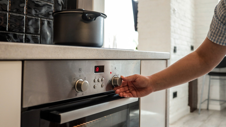 Person adjusting the oven temperature
