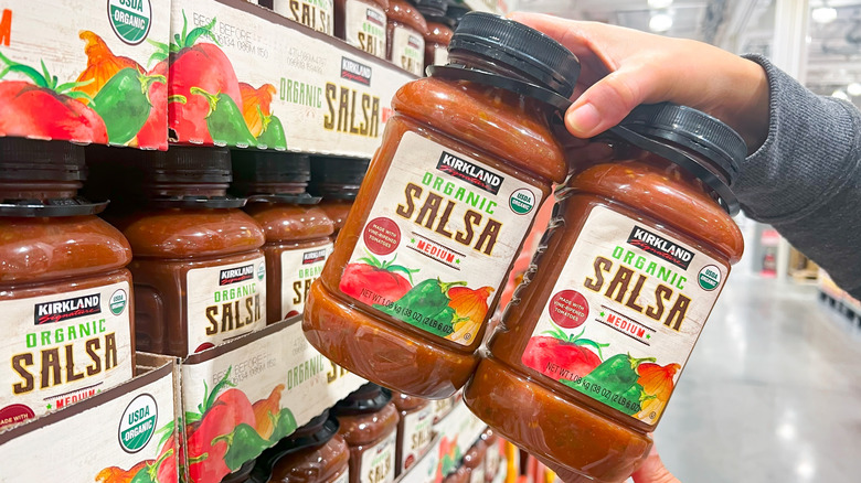 hands holding jars of Kirkland Signature salsa