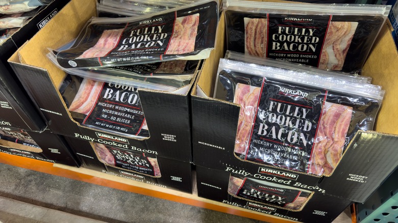 Packages of Costco's fully cooked bacon in a display