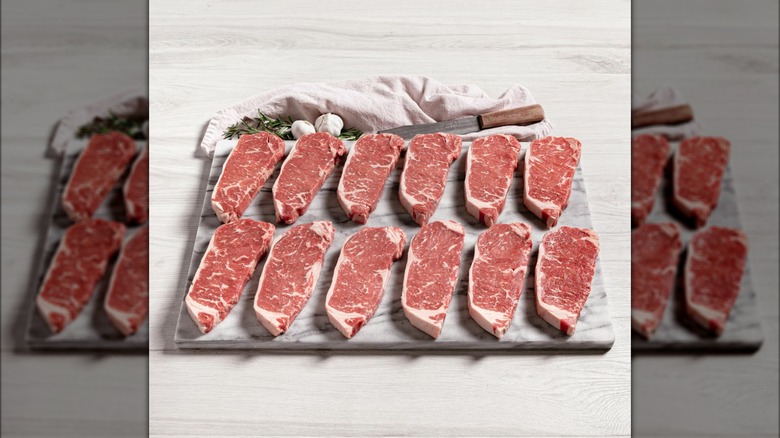 12 steaks on a cutting board
