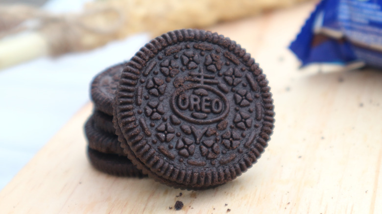 Oreo cookies on a wooden board with a package in the background