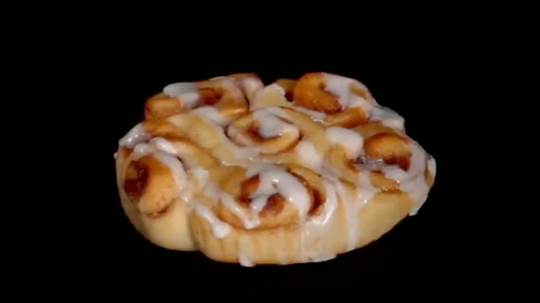 Chik-fil-A cinnamon clusters topped with icing, on black background.