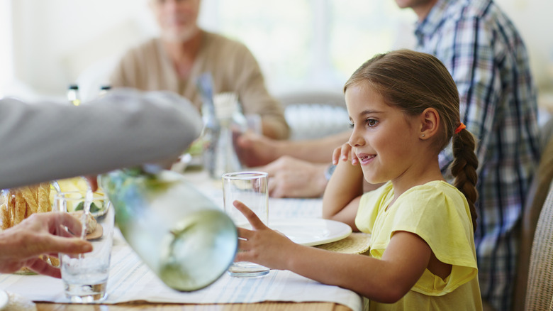 Family sharing water at table