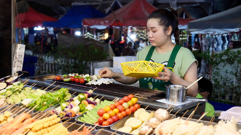 Woman serving food at night market inLaos