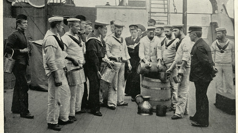 Black and white vintage photo of sailors receiving their grog rations
