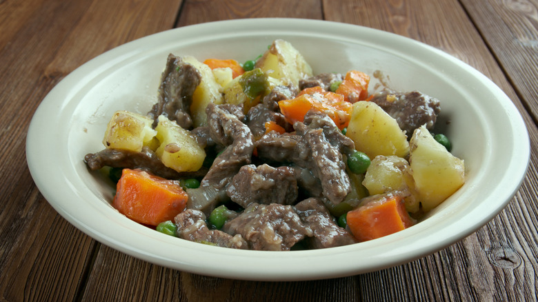 White bowl of scouse on a wooden table