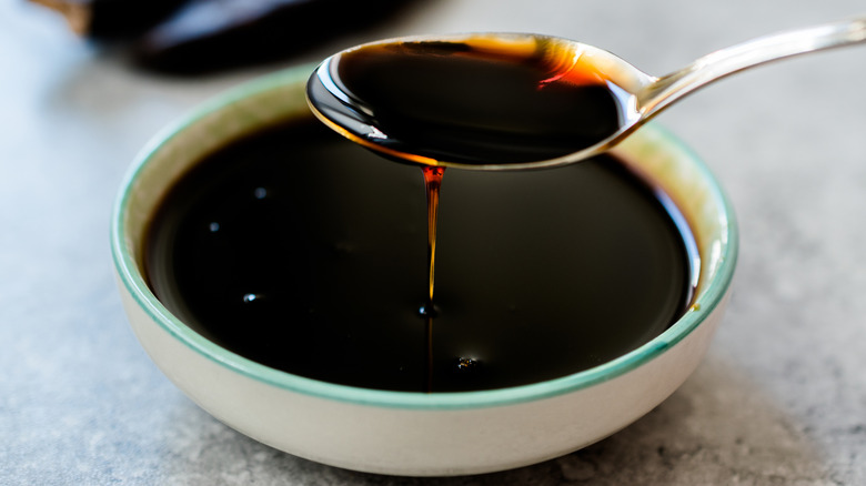 spoon dripping molasses into a molasses-filled bowl